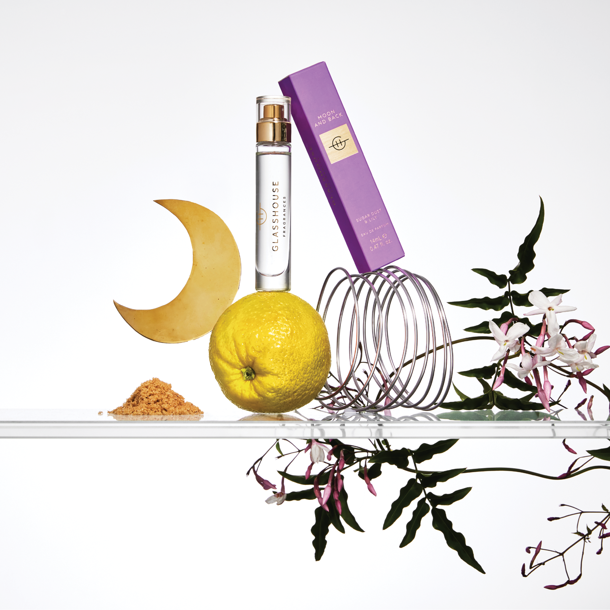 Glasshouse Fragrances Moon & Back 14ml Eau de parfum with box on glass shelf with lilies & citrus.